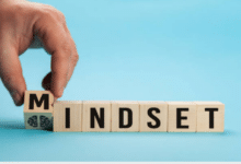 Mano umana tocca uno di sette dadi che formano la parola mindset
