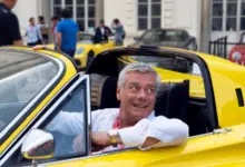 Uomo di mezza età di successo guida una ferrari gialla
